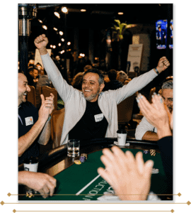 A man raises his hand in the air in triumph after winning a poker hand.