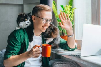 man drinking coffee looking at his computer